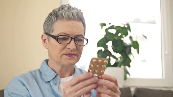 Vrouw Overweegt Zorgvuldig Voor Haar Voorgeschreven Medicijnen — Stockvideo