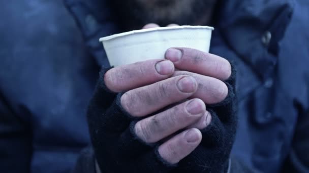 无家可归的男人 在寒冷中战战兢兢 手里拿着纸杯 手里拿着某种饮料 — 图库视频影像