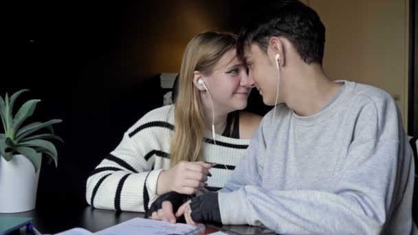 宿題の休憩中に音楽を聴いているロマンチックなカップル — ストック動画