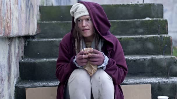 Бездомная Молодая Женщина Дрожа Холода Жадно Ест Завернутое Бумагу Одета — стоковое видео