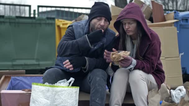 Two Dirty Poorly Dressed Homeless People Man Woman Sit Pile — Stockvideo