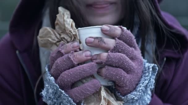 집없는 여자가 추위에 떨면서 더러운 음료수가 종이컵을 있습니다 — 비디오