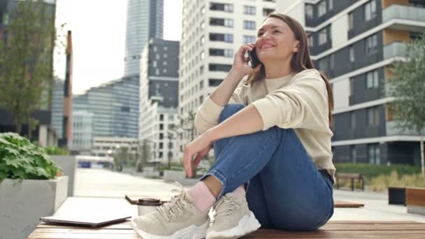 Young Cheerful Woman Talking Smartphone While Sitting Street Modern European — Αρχείο Βίντεο
