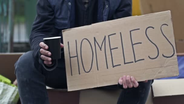 Egy Semmirekellő Férfi Egy Kolduló Pohárral Egy Kézzel Írott Homeless — Stock videók