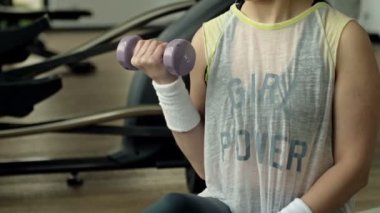 Slim girl doing workout with a dumbbells. Fitness girl pumping arms. HD.