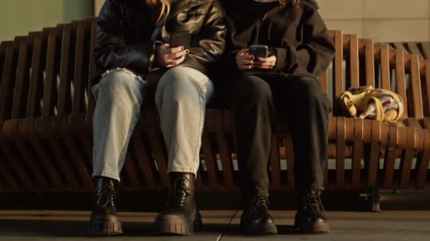 Two Girls Sitting Bench Train Station Smartphones Hands — Stockvideo