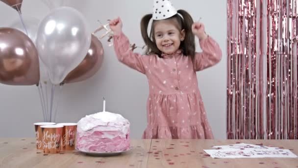 一个小女孩的生日 孩子很高兴 装饰得漂亮的房间 一个蛋糕 一个闪闪发光的意大利面 — 图库视频影像