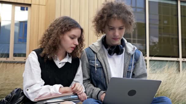 귀여운 고등학생 남학생 여학생 운동장 벤치에 있습니다 대들은 노트북 화면을 — 비디오