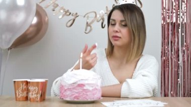 Beautiful young woman tries cream from a birthday cake. HD.