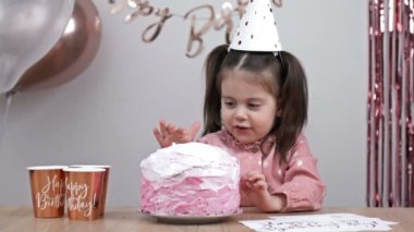 Little birthday girl tries the cream on the birthday cake. HD.