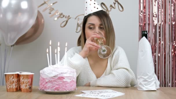 漂亮的年轻女子在生日那天一个人喝酒 她伤心地把生日蛋糕上的蜡烛吹灭了 — 图库视频影像