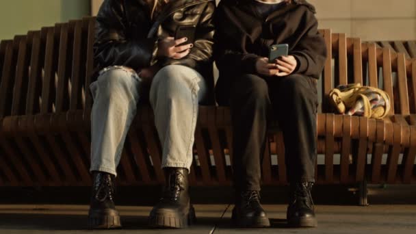 Two Girls Sitting Bench Train Station Smartphones Hands — Vídeo de Stock