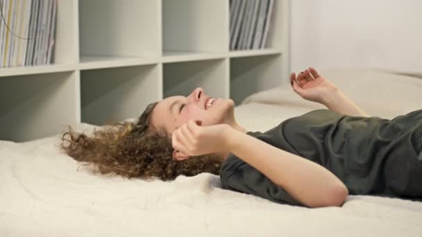 소녀는 웃으면서 침대에 떨어진다 — 비디오