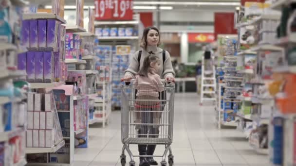 Piękna Młoda Kobieta Przechodzi Przez Supermarket Wózkiem Którym Siedzi Mała — Wideo stockowe