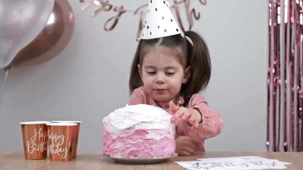 小さな誕生日の女の子は誕生日ケーキのクリームを試してみてください — ストック動画