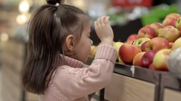 Menina Toca Maçãs Uma Prateleira Supermercado — Vídeo de Stock