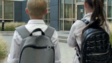 Group of elementary school students rush to a lesson to school. Back to school. 4K.