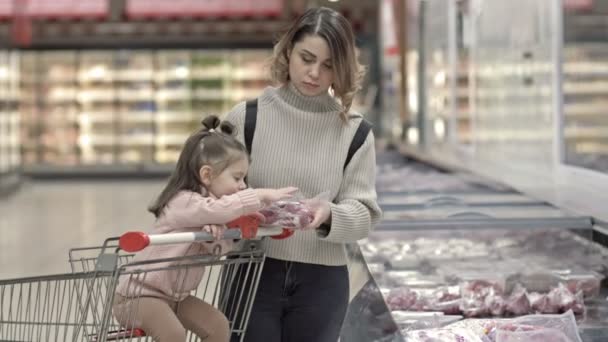 Young Woman Her Little Daughter Showcases Meat Supermarket Child Sits — Stock Video