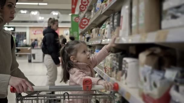 Junge Mutter Mit Kind Neben Den Regalen Mit Produkten Supermarkt — Stockvideo
