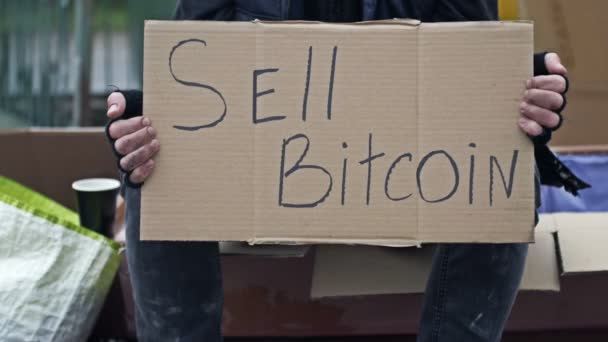 Невдячний Чоловік Сидить Чашкою Напою Тримає Ручний Плакат Sell Bitcoin — стокове відео