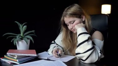 Yorgun öğrenci üniversite derslerine hazırlanırken defterleri üzerinde uyuyakalıyor. 4K.