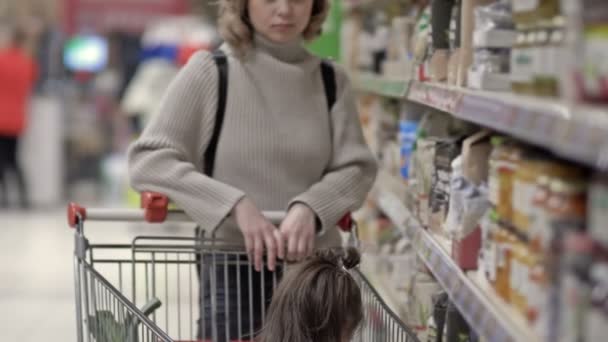 Jovem Com Sua Filhinha Está Comprando Supermercado Criança Senta Carrinho — Vídeo de Stock