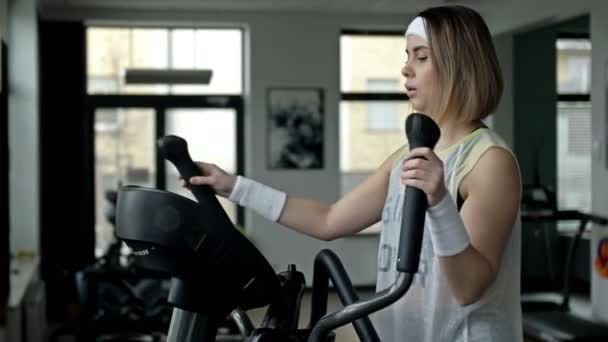 Starke Junge Schöne Frau Ist Einem Fitnessstudio Auf Einem Ellipsoid — Stockvideo