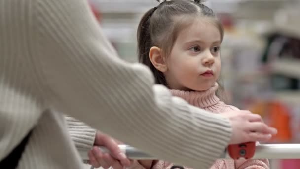 Küçük Kız Bir Süpermarkette Alışveriş Arabasında Oturuyor — Stok video