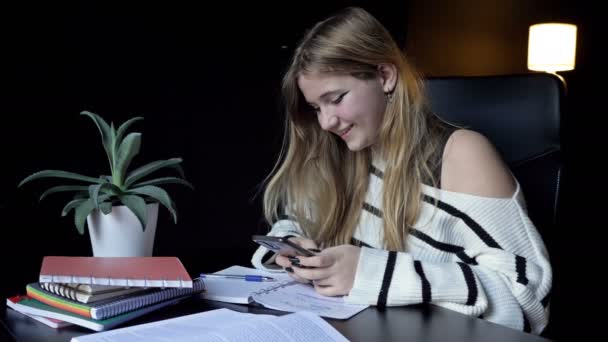 女子学生は講義の準備をしている 彼女はスマートフォンを使っている — ストック動画