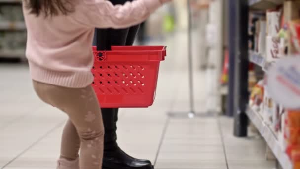 Ноги Жінки Червоним Продуктовим Кошиком Біля Полиці Супермаркеті Маленька Дівчинка — стокове відео