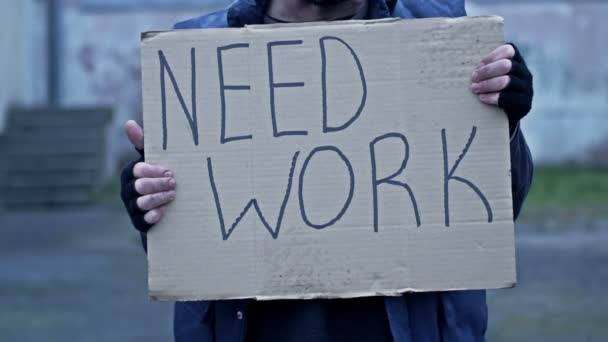 Nieporządny Mężczyzna Siedzi Ulicy Trzyma Odręcznie Napisany Plakat Need Work — Wideo stockowe