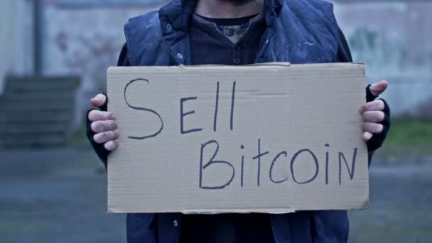 Ein Ungepflegt Aussehender Mann Hält Ein Handgeschriebenes Sell Bitcoin Poster — Stockvideo