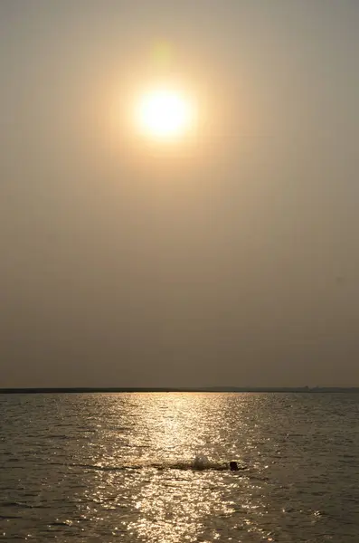 Morning sun in a haze above the sea and sun glare on the water