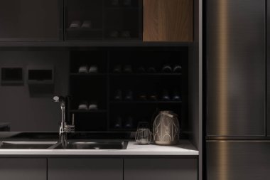 Siyah dolapları ve beyaz tezgahları olan küçük bir mutfak..