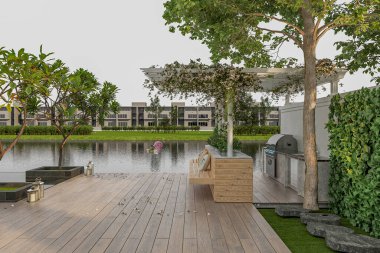 Güzel göl manzarası, ahşap güverte ve modern bir tatil köyünde göletin yanında oturma yeri.