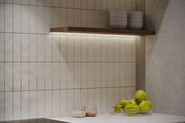 Modern mutfak tezgahının ahşap bir rafı, beyaz bir döşemesi ve bir kase yeşil elması var..