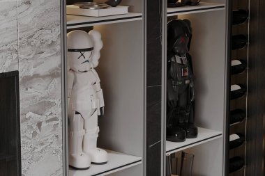 Beyaz Star Wars Stormtrooper figürlü bir raf ve oturma odasında siyah Darth Vader figürü.