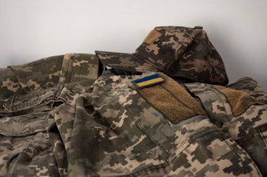 Bir askerin piksel kamuflaj üniformasında Ukrayna bayrağı. Mavi ve sarı renklerde Ukrayna bayrağıyla donatılmış dijital askeri kamuflaj kıyafeti. Ukrayna asker üniforması