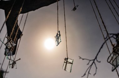 Güneşin önündeki tellerin üzerindeki cam parçalarından oluşan bir grup içinden gelen ışıkla birlikte. Özet, dekor teması