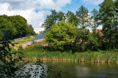 Nehir kıyısında suya yakın güneş panelleri olan küçük bir güneş enerjisi istasyonu. Temiz güneş enerjisi, ekolojik, ekolojik tema