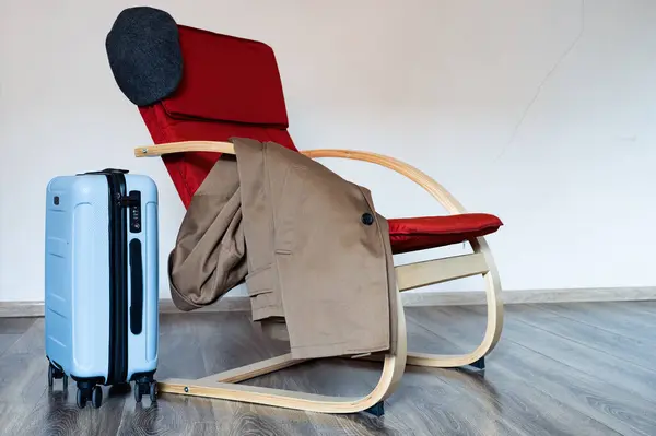 Reisekoffer Steht Neben Rotem Sessel Mit Mantel Und Wählerischem Scheuklappen — Stockfoto