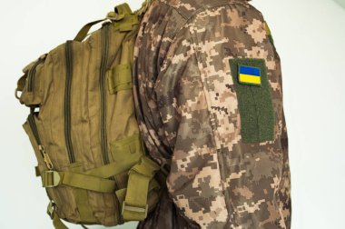 Ukrayna askeri üniformalı, taktik sırt çantalı ve Ukrayna bayrağıyla savaşıyor.