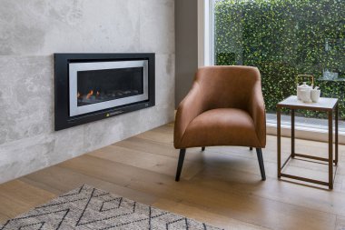 Modern oturma odasının içinde şömine ve koltuk var.