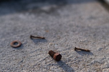 Paslı civata ve vidalar beton zemine saçılmıştı. beyaz arkaplan