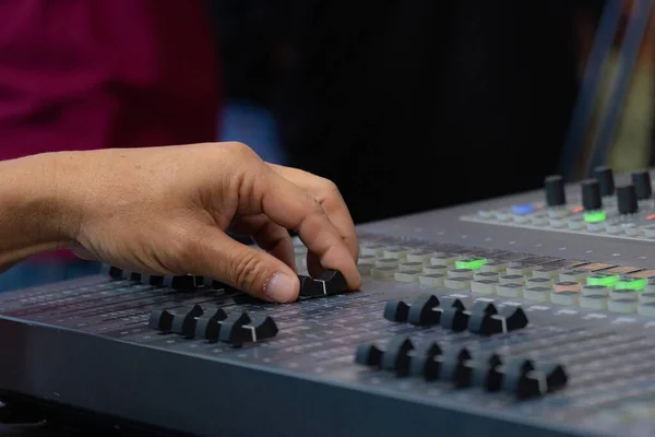 elderly man\'s hand who is controlling the mixer sound system check At the concert, stage, performers with confidence