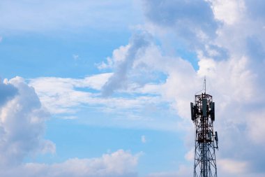 Antenler ve elektrik direkleri Bulutların önünde güneş batarken sırtında çivit bir göbek var.