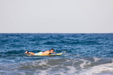 Sörf tahtasında yüzen adam