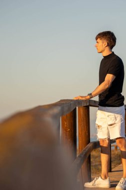 Güneşe bakan genç bir adam podyumda