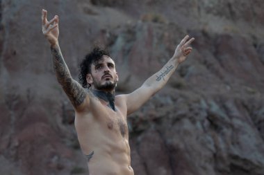 Dövmeli, piercingsiz, üstsüz bir adam.