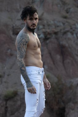 Dövmeli, piercingsiz, üstsüz bir adam.